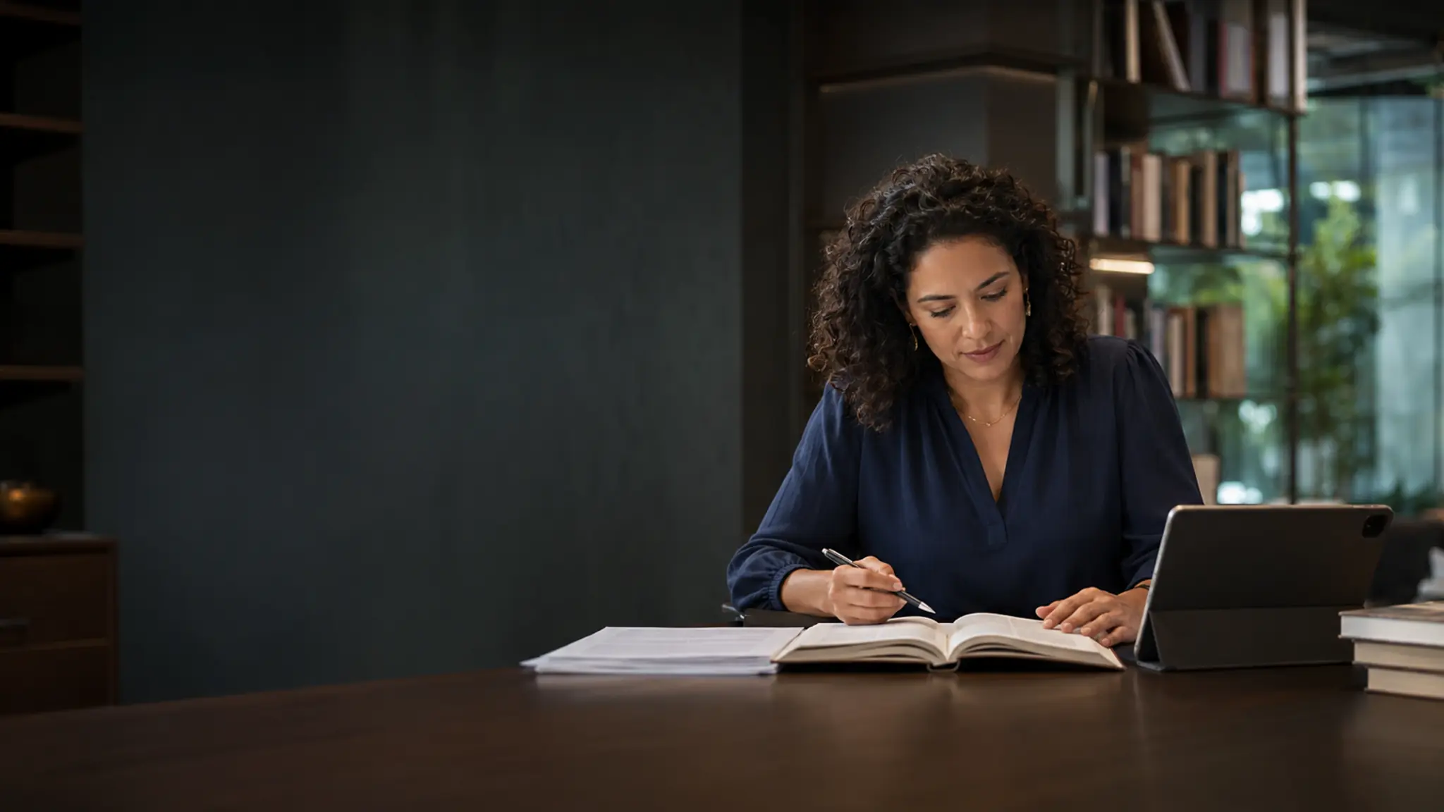 Educadora produzindo conteúdos pedagógicos em uma biblioteca contemporânea